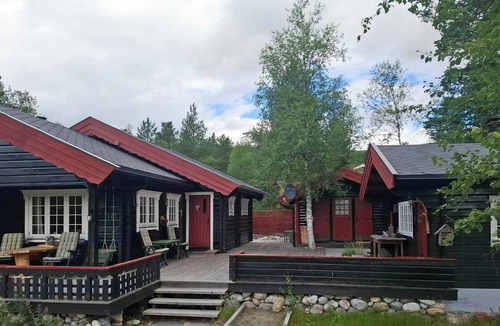 Bjorli House | Family cabin cluster by waterfall in Bjorli