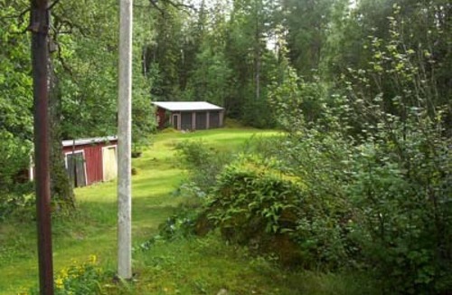 Vissefjaerda House | Red and white cottage with a boat not far from the lake