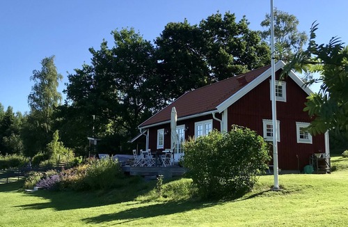 Harnosand Cottage | View of lake and mountains in west orientation, with sauna and jetty