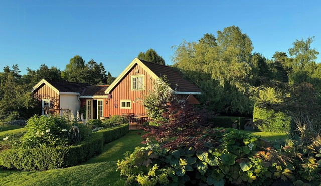 Red country house with lush gardens near Arendal